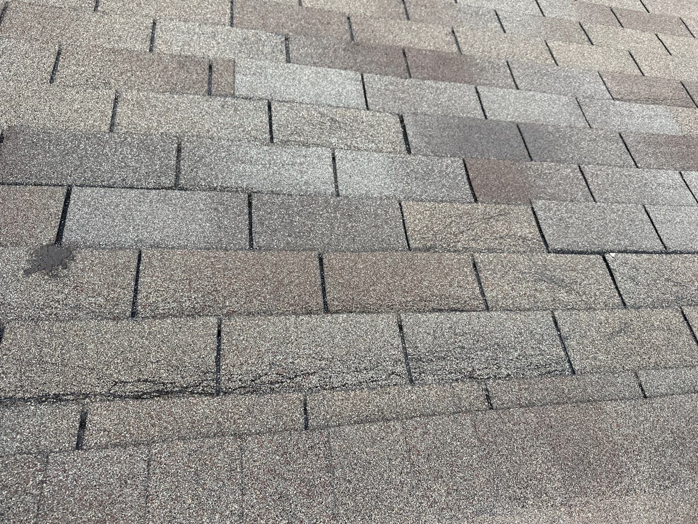 Wind-damaged 3-tab shingles with lifted and missing tabs before the roof replacement in Anna, TX