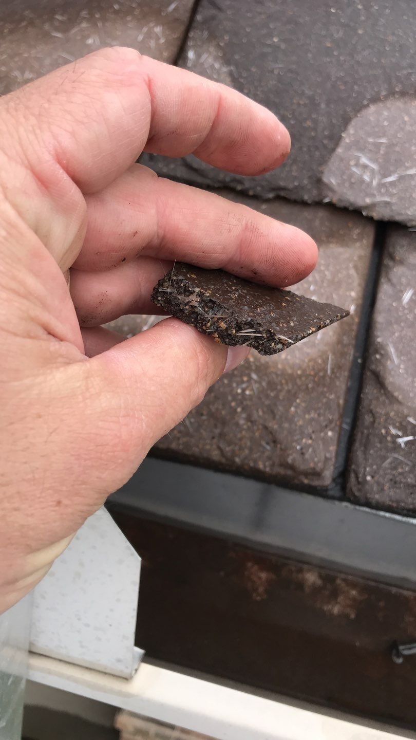 Cracked and displaced concrete tile showing hail damage before the roof replacement in McKinney, TX