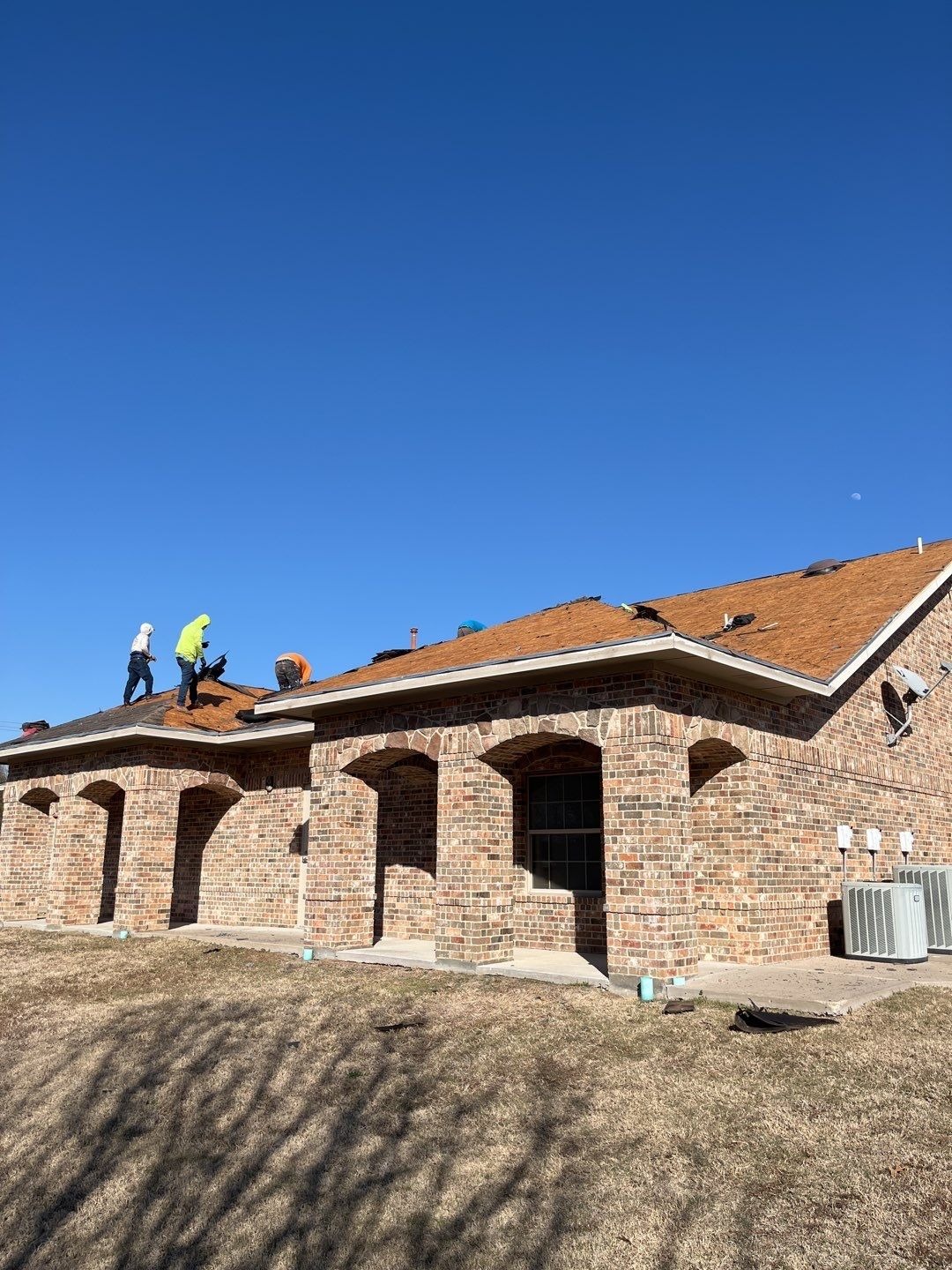 Crew mixing tile from multiple pallets during the roof replacement in McKinney, TX