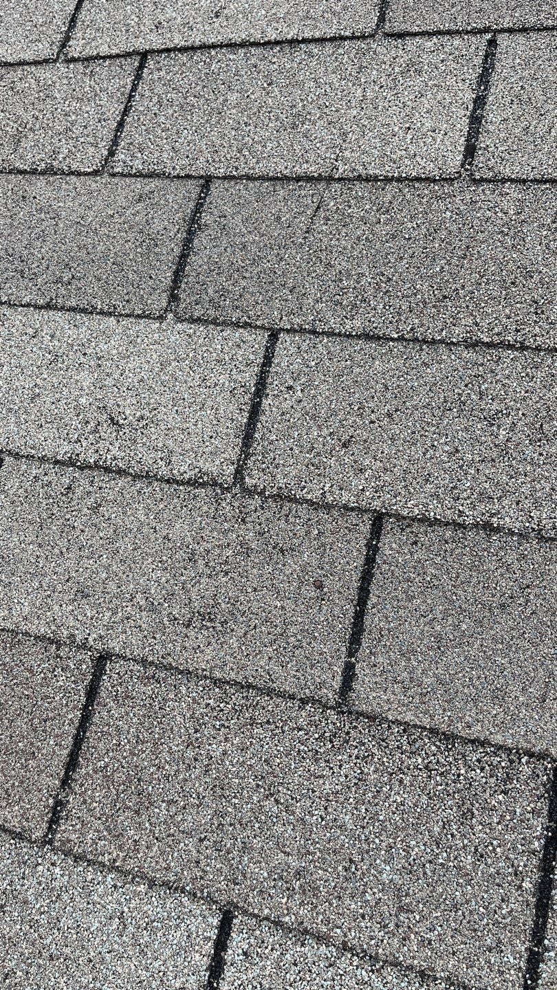 Close-up of storm-damaged shingle mat before tear-off during roof replacement in McKinney, TX