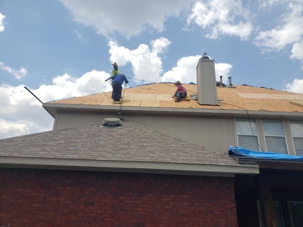 Underlayment being rolled out across the deck during roof replacement in McKinney, TX