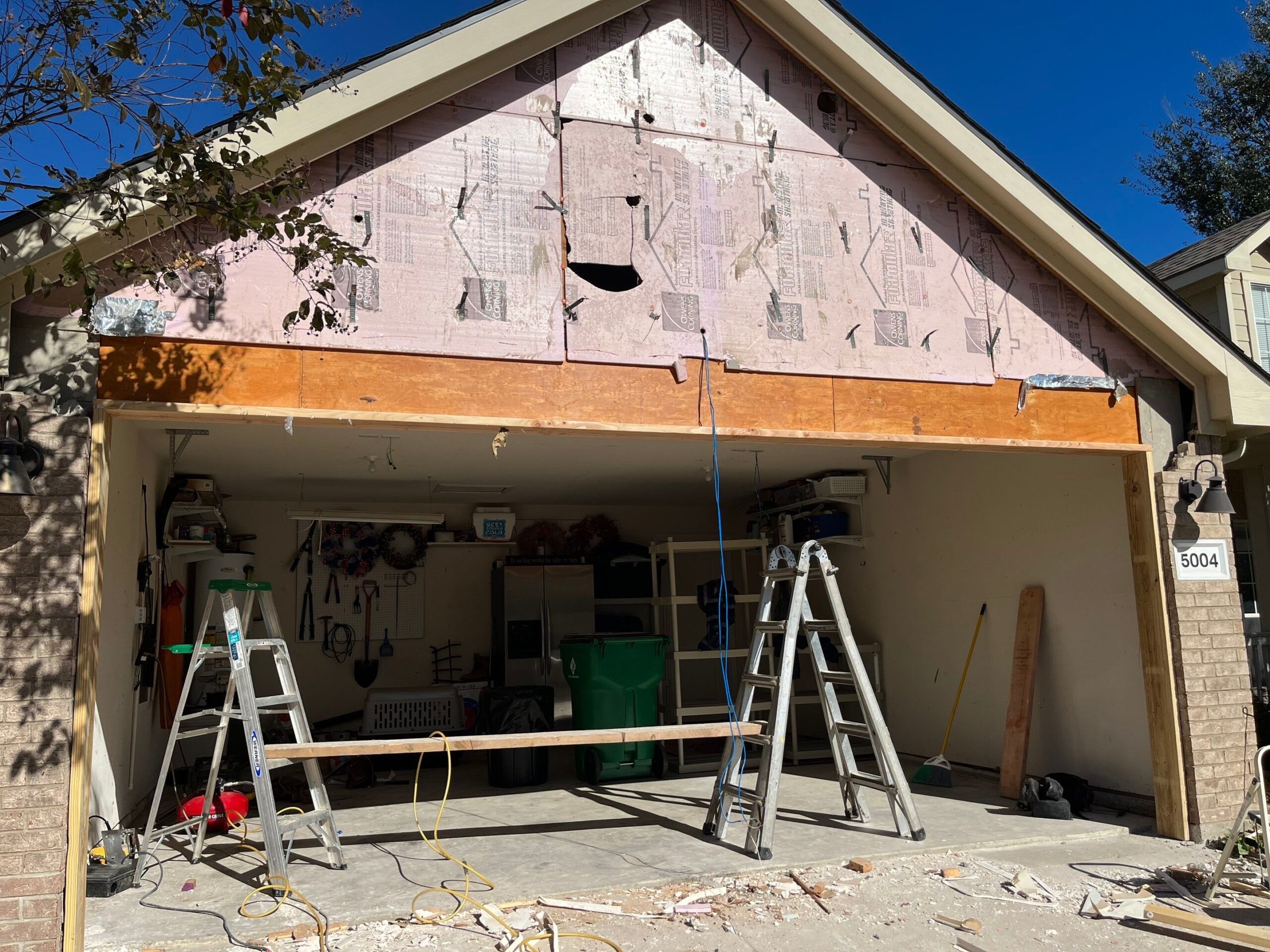 Siding stripped away to expose framing during the McKinney, TX reconstruction